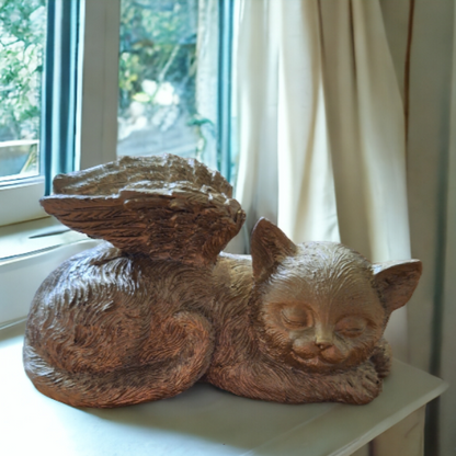 beeld in de vorm van een slapende poes met engelen vleugels