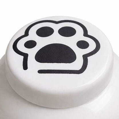 Witte keramische kattenurn met zwarte pootafdruk op het deksel