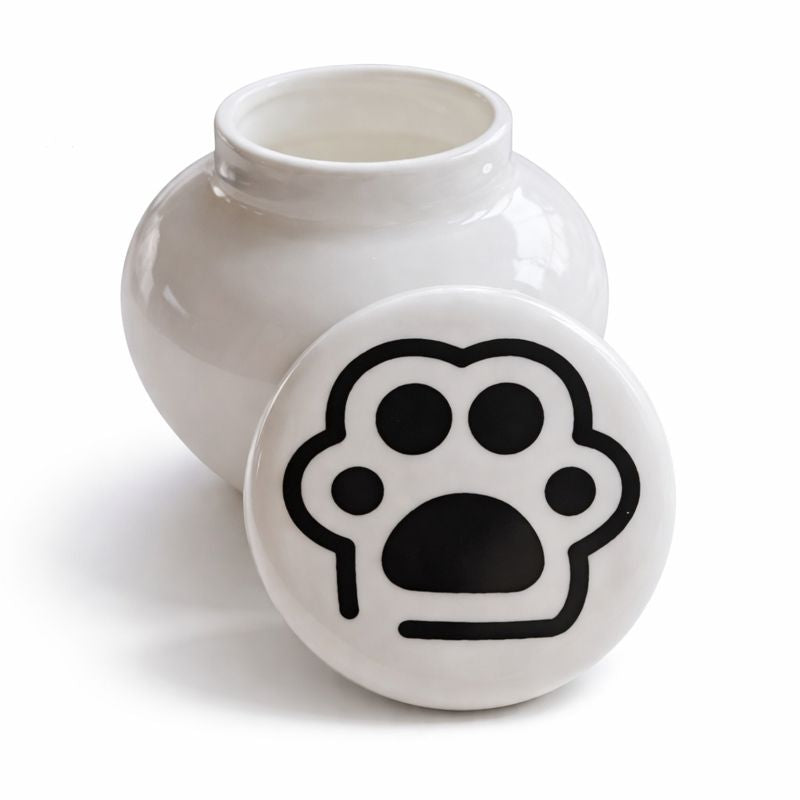 Witte keramische kattenurn met zwarte pootafdruk op het deksel