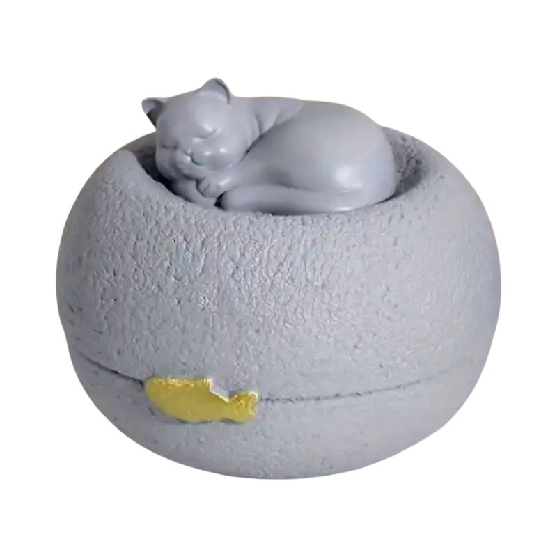 Grijze kattenurn: een vredig slapend poesje bovenop een ronde, steenachtige basis, met een subtiel gouden visje als detail